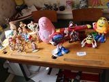 des figurines de jouets posées sur une table en bois dans une pièce encombrée