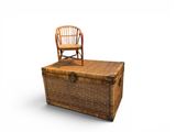 a wicker chest with a chair on top
