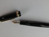 a pen and a ballpoint pen laying on a table