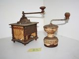two old coffee grinders sitting on a white table