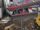 un bateau rouge et blanc posé sur un support dans un garage