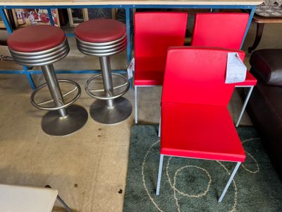 trois chaises rouges et deux tabourets dans une pièce