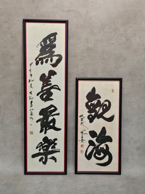 deux calligraphies chinoises accrochées l'une à côté de l'autre sur un mur