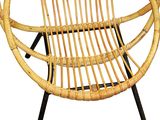 a wicker chair that is sitting on a black metal stand