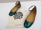a pair of green shoes sitting on top of a white bag