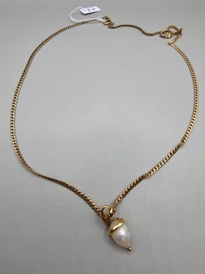 un collier en or avec un pendentif en perle au bout d'une chaîne