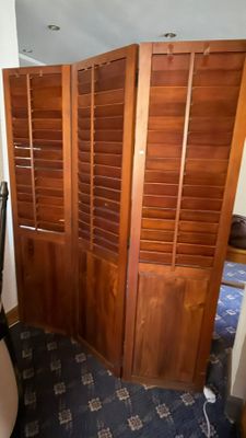 a room with a bed and a closet with wooden shutters