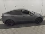 the tesla model y is parked in a garage with a checkered floor
