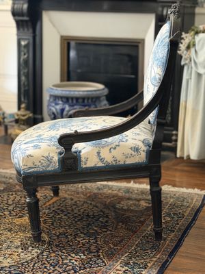 une chaise bleue et blanche placée devant une cheminée