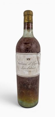 an old bottle of liquor sitting on a white surface