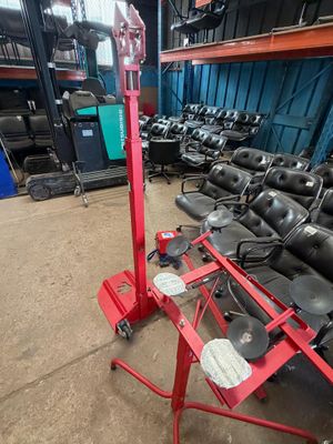 a lot of black chairs in a warehouse with a red stand