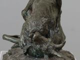 a bronze statue of a bull and a pig on a rock