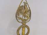 a gold colored bird on top of a metal object
