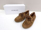 Chaussures Moccali de couleur beige, ornées de pompons et d'un motif en forme de boîte, posées sur un fond blanc