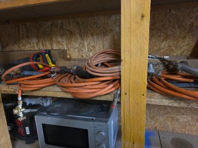 une photo représentant un micro-ondes et plusieurs tuyaux posés sur une étagère