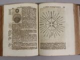 an open book with an image of a sun and a compass on it