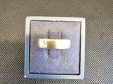 une photo représentant une bague en or dans un coffret en argent posé sur une table