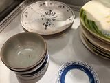 many plates and bowls sitting on a counter