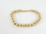un bracelet orné de perles dorées sur fond blanc