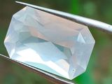 un diamant blanc maintenu par une paire de pinces