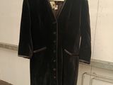 a black jacket hanging on a hanger in a room
