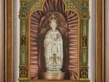 a painting of a statue of the virgin of guadalupe in a wooden frame