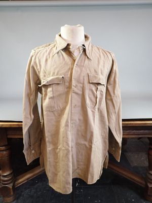 shirt on a mannequin stand in front of a painting