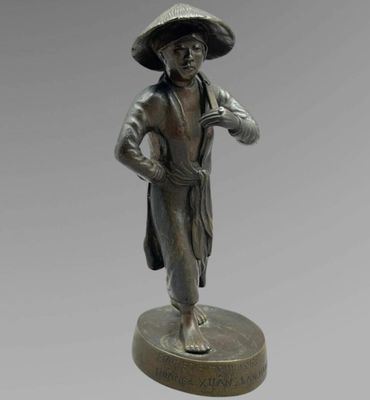 une statue en bronze d'un homme avec un chapeau sur la tête