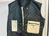 un gilet matelassé noir suspendu à un portant dans un magasin de vêtements