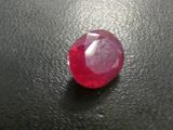 a close up of a red ruby stone on a black surface