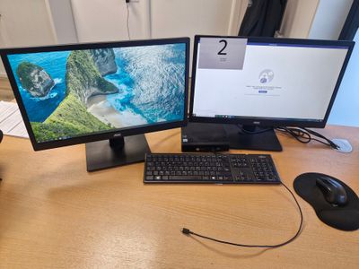 deux écrans d'ordinateur et un clavier sur un bureau