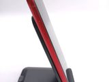 a red and black cell phone sitting on a stand