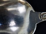 a silver spoon that is sitting on a black surface