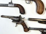 several old guns are displayed on a white surface with a white background