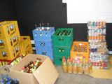 many boxes of sodas and bottles of soda in a room