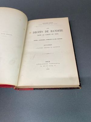 Quelqu'un tient un livre ouvert sur une table, sur fond bleu.