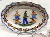 a plate with a picture of a woman on it and a bowl with a spoon on it