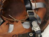 an old helmet with a metal buckle on it sitting on top of a table