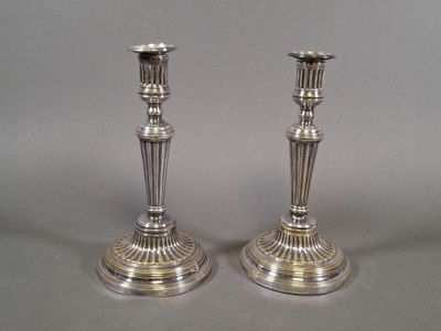 pair of silver plated candlesticks on stands on a grey background