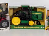 three different models of tractors in boxes on a table