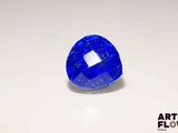 a close up of a blue sapphire stone on a white surface