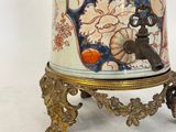 a vase that is sitting on a stand on a white surface
