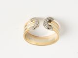 gros plan d'une bague en or et diamants sur une surface blanche