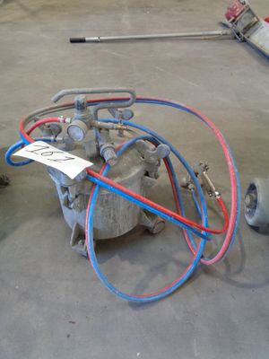 a machine that is sitting on the ground next to a hose