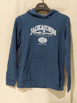 le dos d'un sweat-shirt bleu suspendu à un cintre accroché au mur