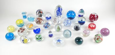 de nombreuses billes de verre de différentes couleurs sur une surface blanche