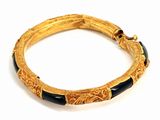 an image of a gold and black bracelet on a white surface