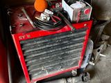 une machine rouge et noire et quelques outils dans un garage