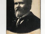 an old photo of a man with a beard and a pipe in his mouth