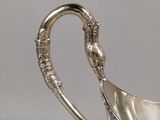 an antique silver plated gravy dish with a handle and handles